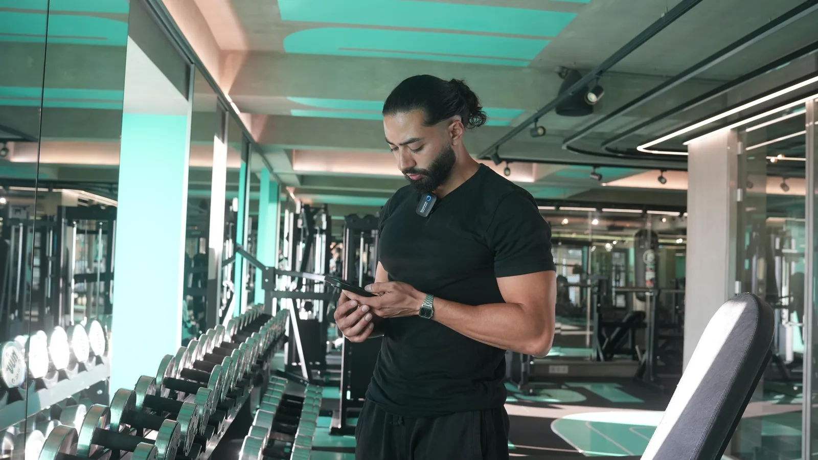 Physio coach reviewing client details in a gym environment